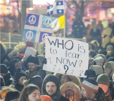  ?? RYAN REMIORZ / THE CANADIAN PRESS ?? People attend a vigil for victims of the mosque shooting in Quebec City Monday. The mosque had been the target of hatred in recent months, with swastikas painted on the wall and a pig’s head left outside on one occasion.