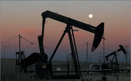  ?? GARY KAZANJIAN — THE ASSOCIATED PRESS FILE ?? Oil derricks are busy pumping as the moon rises near the La Paloma Generating Station in McKittrick, California. The U.S. is on pace to leapfrog both Saudi Arabia and Russia as the world’s biggest oil producer.