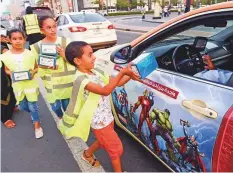  ??  ?? Above right: Young volunteers from Al Ihsan Charity Associatio­n distribute iftar packs to motorists near City Walk in Dubai.