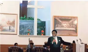  ??  ?? KAREN PULFER FOCHT, THE COMMERCIAL APPEAL Al Green sings and prays with worshipers at his Full Gospel Tabernacle church in Memphis. The church opened on Dec. 18, 1976.