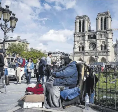  ?? Miguel Medina / AFP ?? Un sintecho frente a la catedral de Notre Dame de París, el 4 de abril.