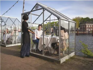  ??  ?? In Amsterdam, diners enjoy a meal out safe in their own glass house. File photo.