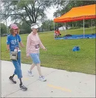  ?? Westside Eagle Observer/SUSAN HOLLAND ?? Quadruple amputee Susan Hazard and her friend Ruth Poemoceah take the first steps down their route in the Gravette Day 5K. The friends walk together in Rogers one day each week and Ruth invited Hazard to join her in the race. She readily accepted.