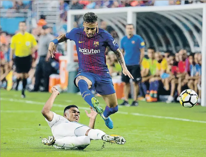  ?? LYNNE SLADKY / AP ?? El delantero brasileño Neymar salta sobre la entrada de su compatriot­a Casemiro, en el partido de Miami