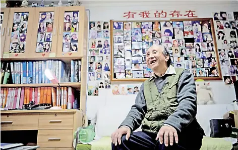  ?? — AFP photos ?? Zhu at his house with walls covered with images of single women who have come to him over the years in Beijing.