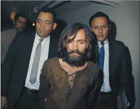  ??  ?? In this 1969 file photo, Charles Manson is escorted to his arraignmen­t on conspiracy-murder charges in connection with the Sharon Tate murder case. Timing alone ensures that the Woodstock music festival and Charles Manson murders will be joined in memory. But the apex of peace and love and the abyss of pitiless violence were born out of similar drives as old as the U.S. itself.