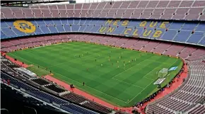  ??  ?? Protest: FC Barcelona play Las Palmas in an empty Camp Nou stadium yesterday, left, after walking out wearing Catalan colours, right