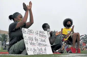  ?? Helen H. Richardson, The Denver Post ?? From left, MiDian Holmes, Sylvia Akol and Sheree Barbour, listen to music during an event, Gathering in Gratitude presented by Motherhood, held to honor the memory of Elijah McClain on Aug. 23 in Denver. McClain died after being stopped by police last year in the suburb of Aurora.