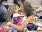  ?? CORPUS CHRISTI CALLER- TIMES ?? Heather Howard and her daughter, Emma, 2, wait to evacuate Corpus Christi as Hurricane Harvey nears.