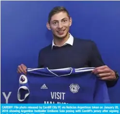  ??  ?? CARDIFF: File photo released by Cardiff City FC via Noticias Argentinas taken on January 20, 2019 showing Argentine footballer Emiliano Sala posing with Cardiff’s jersey after signing for the club, in Cardiff, UK. — AFP