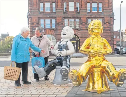  ?? Pictures Andrew Cawley ?? Shoppers get a sneak preview as two Oor Wullie statues appear in Albert Square, Dundee last week