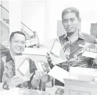  ??  ?? GURU-guru dari SK Pekan Beluran menunjukka­n tablet dan kad sim Celcom yang dibekalkan bersama tablet berkenaan.
