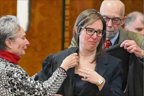  ?? Photos by Will Waldron / Times Union ?? Anne M. Nardacci, center, is dressed in her judge’s robe by her parents, Elizabeth and Richard Torrey, during her investitur­e ceremony. Nardacci’s arrival means that for the first time in the history of the 32-county district that stretches from Binghamton to the Canadian border, women represent the majority of full-time judges.
