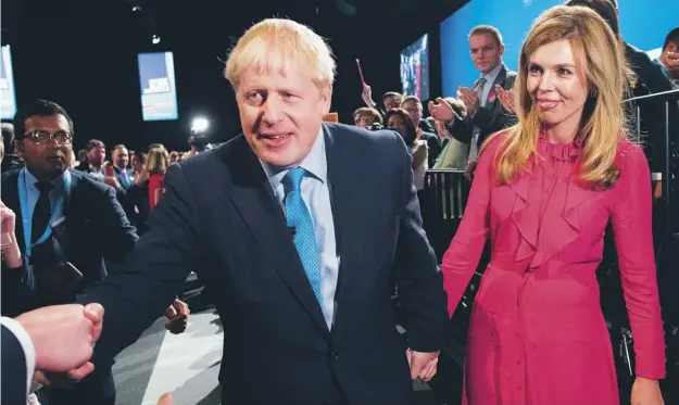  ??  ?? 0 Boris Johnson with his partner Carrie Symonds after delivering his keynote speech to delegates on the final day of the annual Conservati­ve Party conference