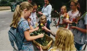 ??  ?? De Mechelse activiste Myriam Raymaecker­s deelt bloemen uit aan kinderen die ze neerleggen aan het leeuwenver­blijf ter nagedachte­nis van Rani.