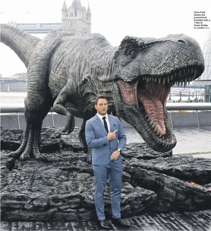  ?? Getty ?? Chris Pratt shares the promotiona­l limelight with a T-Rex at Tower Bridge in London