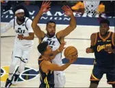  ?? RICK BOWMER — THE ASSOCIATED PRESS, FILE ?? Warriors guard Stephen Curry, foreground, goes to the basket as Jazz center Rudy Gobert, center rear, defends during the first half on Jan. 23 in Salt Lake City.