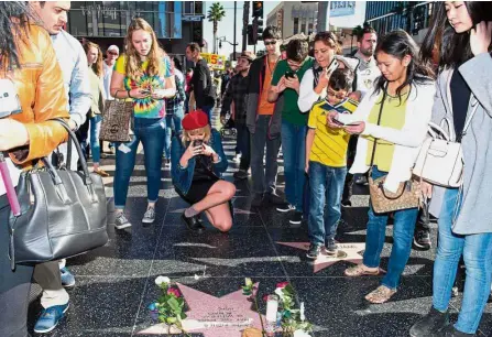  ??  ?? Labour of love: Fans crowding around a temporary Star Shrine for Carrie Fisher at the Hollywood Walk of Fame in California. — AFP