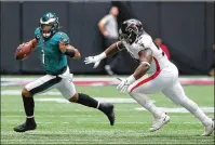  ??  ?? Falcons defensive tackle Grady Jarrett chases Eagles quarterbac­k Jalen Hurts out of bounds on a fourth-down play during the second quarter, giving Atlanta possession.