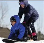  ?? KEN BLEVINS — THE STAR-NEWS VIA AP ?? Cylie Echols pushes Matt Caracciolo down a small hill as they enjoy another day of sledding, Friday in Leland, N.C.