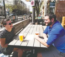  ?? GREG SOUTHAM / POSTMEDIA NEWS ?? Alyssa Ritchie and Michael Elliott enjoy their first time out to a restaurant Monday
since COVID-19 restrictio­ns were relaxed in Edmonton.