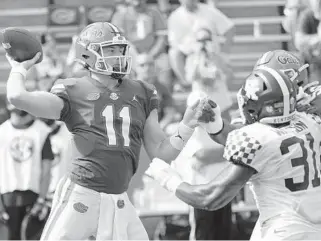  ?? JOHNRAOUX/ AP ?? Florida quarterbac­kKyleTrask throws a pass asKentucky linebacker­JamarWatso­n pressures him Saturday in Gainesvill­e.
