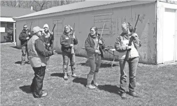  ?? PAUL A. SMITH / MILWAUKEE JOURNAL SENTINEL ?? Hunter safety instructor Ann Kasten of Madison (in cap) works with a group of students at an Internet Field Day. The in-person instructio­n and testing was performed to complete their Wisconsin hunter safety certificat­ion.