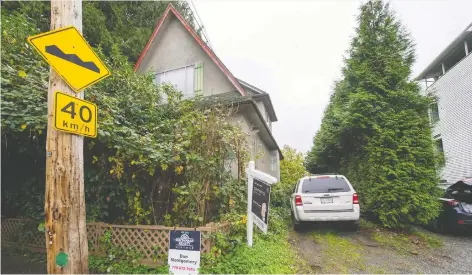  ?? ARLEN REDEKOP ?? A tiny lot is for sale (where white Ford Escape is parked) beside a house which is also for sale on Williams Street in East Vancouver.