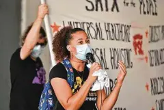  ??  ?? Ananda Tomas with San Antonio Coalition for Police Accountabi­lity and Reform speaks to participan­ts during the San Antonio rally. She challenged the protesters to take action, reach out to legislator­s, vote and run for office.