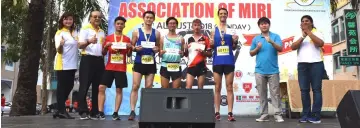  ??  ?? (From right) Vivien, Goh and other organising committee members with the top five winners of the 10km run won by David Patton.