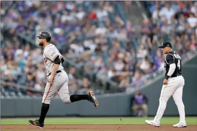  ?? Matthew Stockman
/ Getty Images /TNS ?? Brandon Belt (9) of the San Francisco Giants circles the bases after hitting a solo home run against the Colorado Rockies in the first inning at Coors Field on Sept. 25 in Denver.