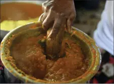  ?? ODELYN JOSEPH/ASSOCIATED PRESS ?? Rose Felicien, 62, mashes baked pumpkin while preparing traditiona­l soup joumou, in the Delmas district of Port-au-prince, Haiti, Sunday, Feb. 5, 2023. Made of pumpkin, beef, carrots, cabbage, ingredient­s produced on the island, soup joumou is a cultural staple in Haiti.