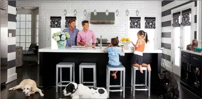  ?? David A. Land/Vern Yip via AP ?? This photo provided by interior designer Vern Yip shows Yip at his home in Atlanta with his family and dogs. Families with pets now have several options for durable, attractive flooring that will stand up to even the most rambunctio­us pets, including...
