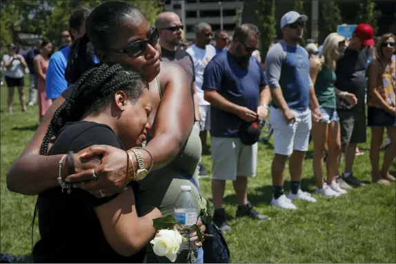  ?? JOHN MINCHILLO — THE ASSOCIATED PRESS ?? Mourners gather at a vigil following a nearby mass shooting Sunday in Dayton. Multiple people in Ohio have been killed in the second mass shooting in the U.S. in less than 24 hours, and the suspected shooter is also deceased, police said.