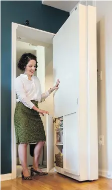  ??  ?? Nicole Buell demonstrat­es how to open the cleverly concealed panels in the door. Secret doors are becoming a bit of a trendy item and fulfil both a practical and an esthetic purpose. Plus, they’re fun.