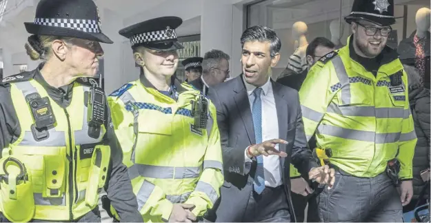  ?? ?? Rishi Sunak speaks to police officers at the corridors of the Swan Walk shopping centre during a visit in Horsham, West Sussex