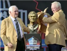  ?? DAVID RICHARD — THE ASSOCIATED PRESS ?? Former NFL executive Gil Brandt, left, and presenter Jerry Jones, owner of the Dallas Cowboys, unveil the bust of Brandt during the induction ceremony at the Pro Football Hall of Fame, Saturday in Canton, Ohio.