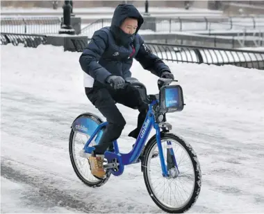  ?? RICHARD PERRY/ THE NEW YORK TIMES ?? A man rides a Citibike during a snowstorm in New York. The Montreal company Société de vélo en libre-service, which filed for bankruptcy protection this week, has supplied the bicycles in the popular bike-sharing programs in major U.S. cities.