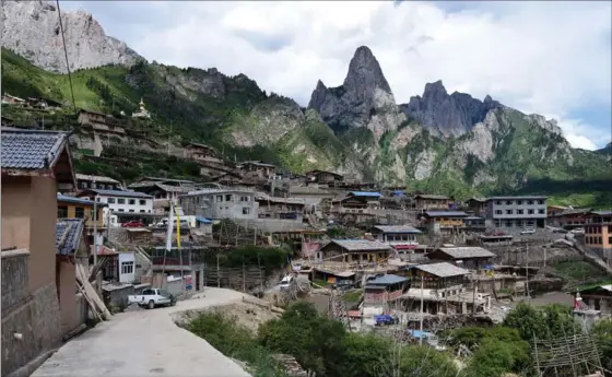  ?? PHOTOS BY WILLIAM FORD, FOR THE WASHINGTON POST ?? A road winds through Zhagana, a village clinging to the mountainsi­de in Amdo. The stunning valley has only recently become known among tourists, and guest houses are popping up.