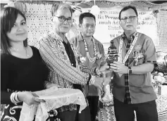  ??  ?? Rolland (right) accepts a memento from Tuai Rumah Anding Galau, as others look on.