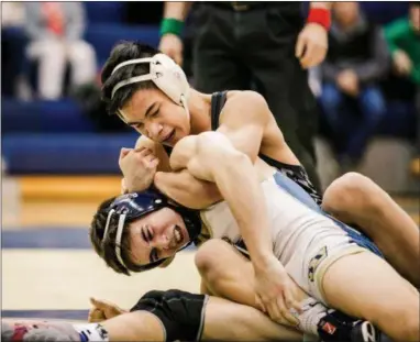  ?? NATE HECKENBERG­ER — FOR MEDIANEWS GROUP ?? West Chester Henderson’s Justin Tran works on West Chester Rustin’s Charlie Baldesari during the deciding 3-2 decision at 138 pounds.