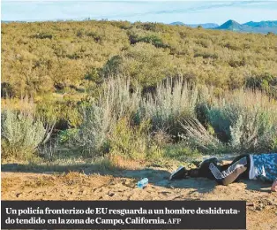  ?? AFP ?? Un policía fronterizo de EU resguarda a un hombre deshidrata­do tendido en la zona de Campo, California.