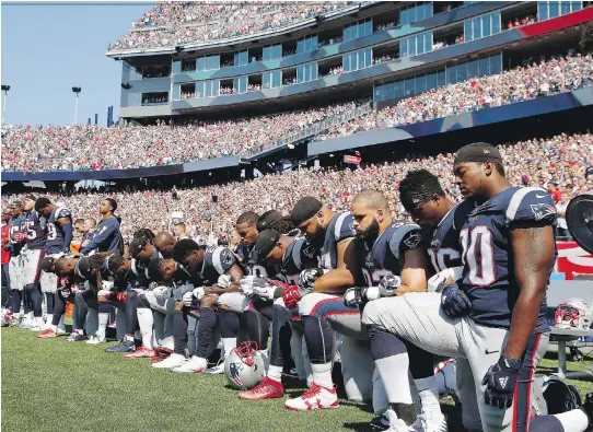  ?? MICHAEL DWYER/THE ASSOCIATED PRESS ?? New England Patriots players kneel during the U.S. national anthem. They were among more than 200 across the NFL who did the same on Sunday.