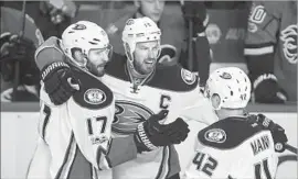  ?? Jeff McIntosh Associated Press ?? AN EMPTY-NET goal by Ryan Getzlaf, center, clinched the Ducks’ first-round sweep of the Flames. Ryan Kesler, left, and Josh Manson join the party.