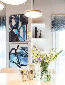  ??  ?? Oben links Moderne Kunstwerke mit türkisblau­er Note ziehen im offenen Wohnbereic­h Blicke auf sich. Oben rechts Kochen und Wohnen gehen fließend ineinander über. Moderner Komfort prägt das Ambiente. Unten Mehrere bequeme Funktionss­essel ersetzen ein einzelnes Sofa.