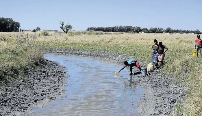  ?? /PHOTOS: TIRO RAMATLHATS­E ?? The community of Lichtenbur­g have been without clean water for over a year and rely on the Harts River for their survival.