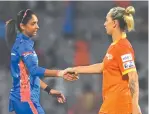  ?? ?? Mumbai Indians captain Harmanpree­t Kaur (left) and Ashleigh Gardner of the Gujarat Giants finish their game on March 4, 2023, at Patil Stadium
WPL DY in Navi Mumbai with a handshake after the Indians won by 143 runs.