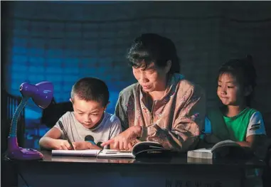  ?? LI PENGCHENG / FOR CHINA DAILY ?? Children in Shijiagou Village, Shanxi province, who are left behind by their parents working in cities, study in a crude environmen­t.