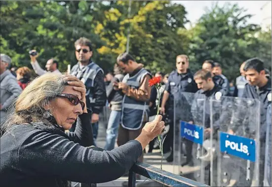  ?? BULENT KILIC / AFP ?? Una mujer, ayer ante la policía antidistur­bios que cerraba el paso a la multitud que quería depositar flores en el lugar del atentado, en Ankara