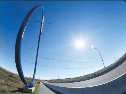  ?? JIM WELLS ?? Calgary’s public art piece called Travelling Light is located near the Airport Trail and Deerfoot Trail NE interchang­e. This 17-metre sculptural ring is integrated into the row of existing street lamps and was completed entirely by local companies at a...